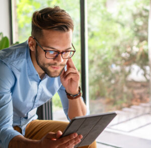 Young amiling Man looking at digital tablet